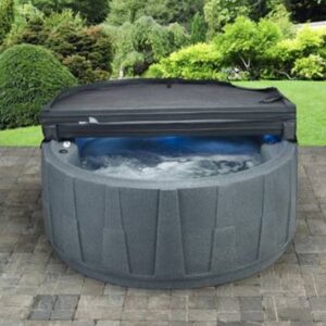 Grijze Dreammaker spa van 200x200x85 cm, gevuld met warm water in een tuinomgeving